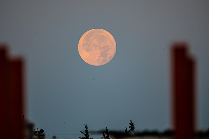 The giant moon during its rising and setting in the village of Deir Ballout, northwest of Syria, on ...