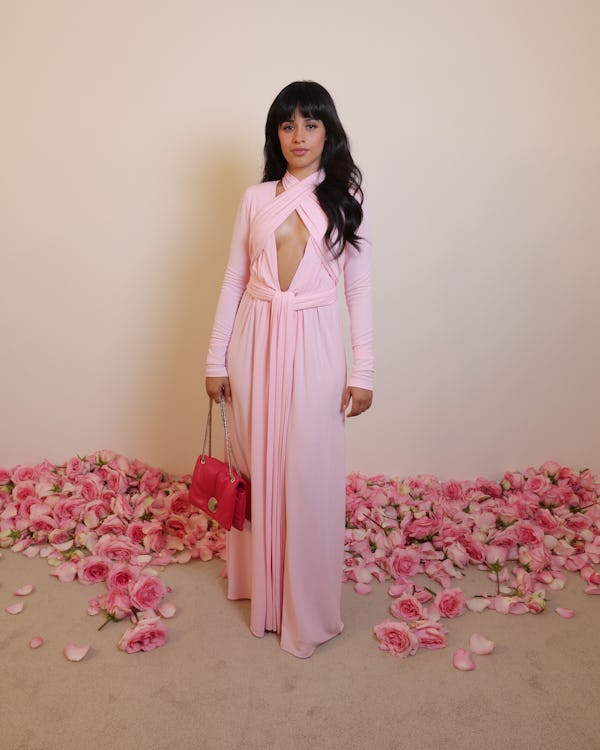 Camila Cabello wears a baby pink jersey dress with a plunging neck and criss-cross halter detail to ...