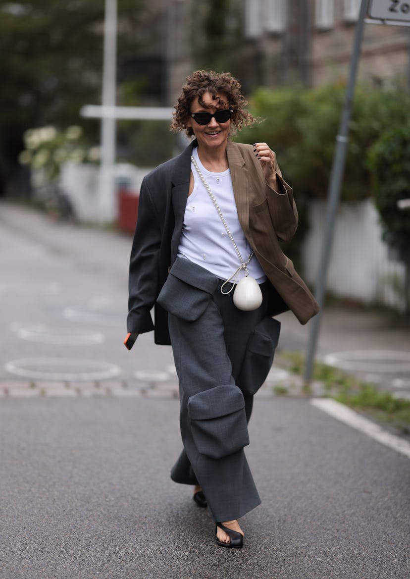 COPENHAGEN, DENMARK - AUGUST 09: A guest wears Bottega Veneta black sunglasses, white cotton tank to...
