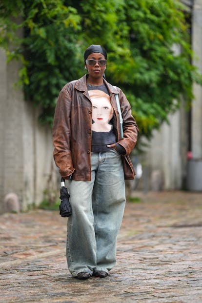 COPENHAGEN, DENMARK - AUGUST 09: A guest wears a black silk scarf as a headband, black sunglasses, a...