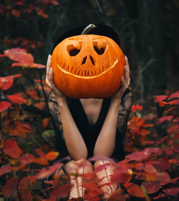 The girl sits in the forest and holds a pumpkin in her hands in halloween captions roundup