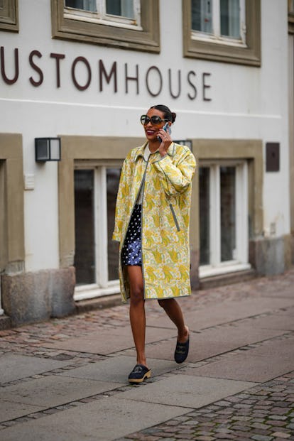 COPENHAGEN, DENMARK - AUGUST 09: A guest wears black sunglasses, gold earrings, a white wool pullove...