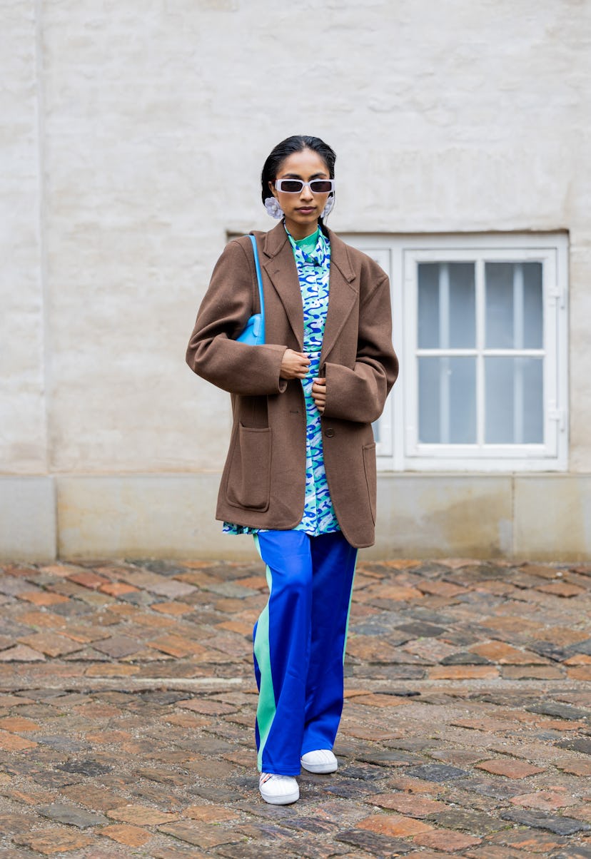 COPENHAGEN, DENMARK - AUGUST 09: Malvika Sheth wears brown oversized jacket, blue pants with green s...
