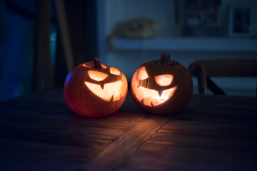 Halloween pumpkins with a candle inside as decoration in roundup of spooky halloween captions