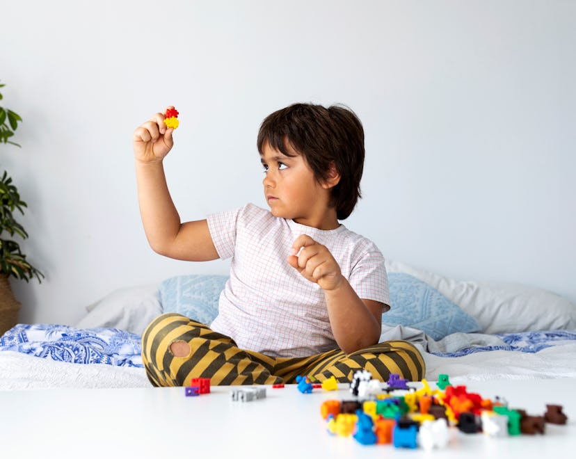 kid playing with LEGO alternative, plus plus puzzle building pieces