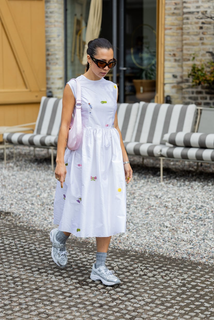 COPENHAGEN, DENMARK - AUGUST 10: Nicole Huisman wears white dress, pink bag, socks, sneaker outside ...