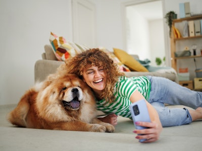 Smiling woman taking selfie with her cute Chow dog