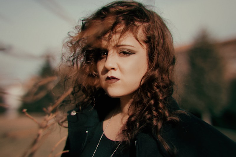 Young woman headshot portrait looking intensely at camera in Winter afternoon