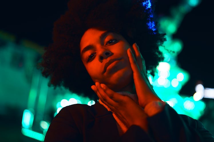 young woman poses with her hands on her face as she considers the August 2023 super blue moon spirit...