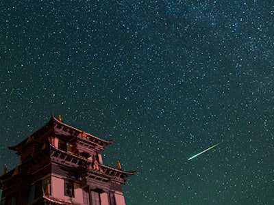GOLOG, CHINA - AUGUST 13: A meteor streaks across the sky during the Perseid meteor shower on August...