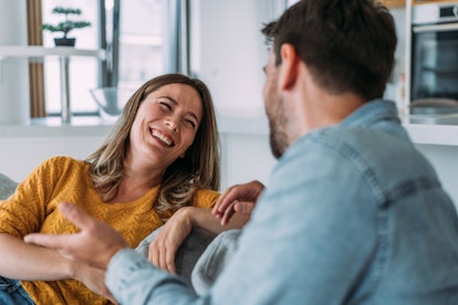 Shot of a smiling young couple talking together while relaxing on the sofa at home.