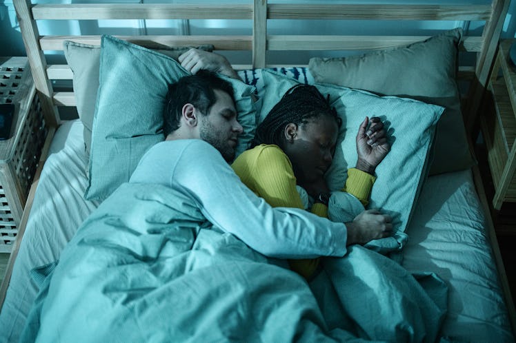 Couple cuddling together in the bed sleeping at night