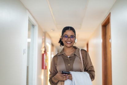 Portrait of a young female doctor in a hallway. She wears casual attire