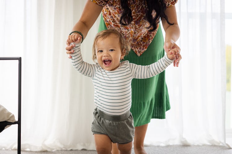 A mom helping her baby walk.