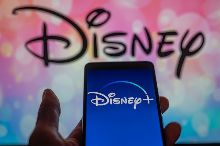 Disney + streaming icon displayed on smartphone with Walt Disney seen in the background. On 12 Augus...