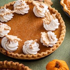 Traditional Thanksgiving pumpkin pie with flaky crust topped with whipped cream