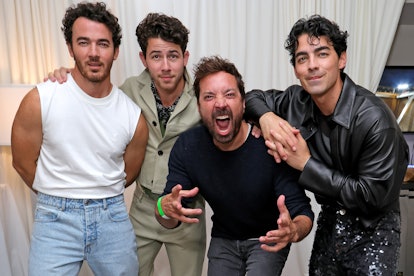 Kevin Jonas, Nick Jonas, and Joe Jonas pose backstage with their surprise guest, Jimmy Fallon, durin...