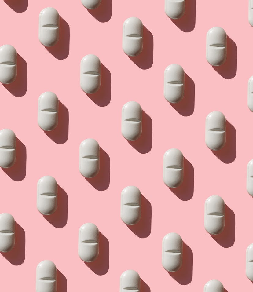 an image of a white pill on a pink background, in an article about zuranolone, the postpartum depres...