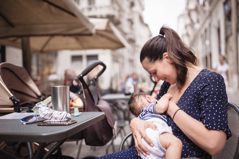 Young mother breastfeeding her baby boy in public place, wondering if breast milk can go bad inside ...