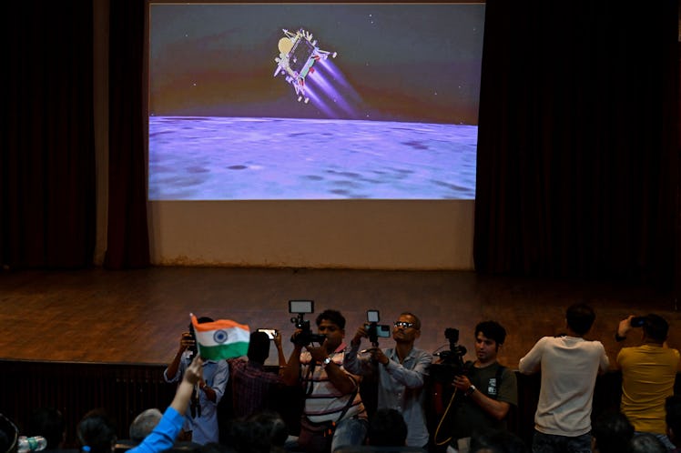 People watch a live stream aired by Indian Space Research Organisation (ISRO) website at the Nehru S...