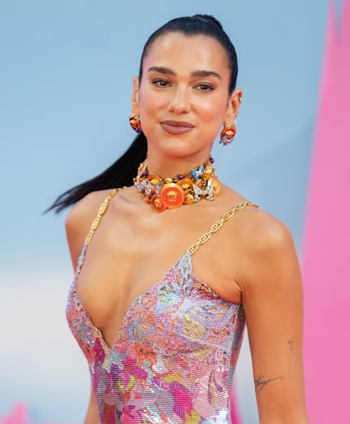Dua Lipa wears a sparkly slip dress and choker necklaces.