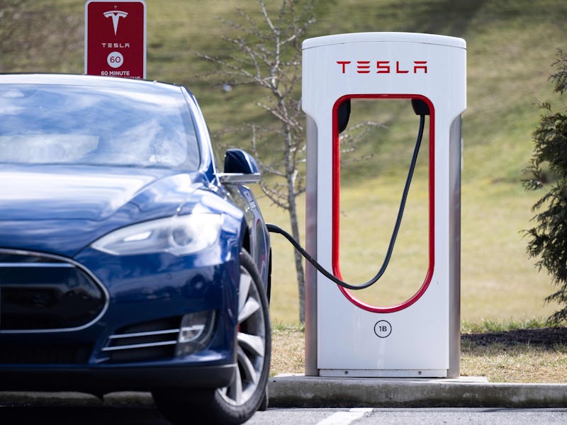 A Tesla Model S sedan is plugged into a Tesla Supercharger electrical vehicle charging station in Fa...