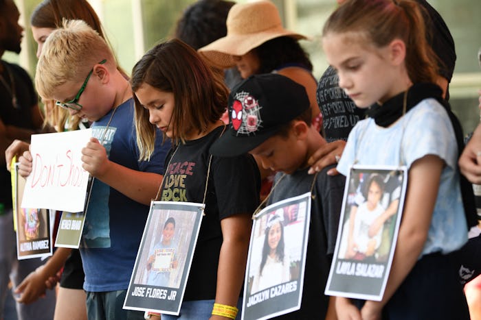 Children holding photos of victims of the Robb Elementary School shooting, participate in a minute o...