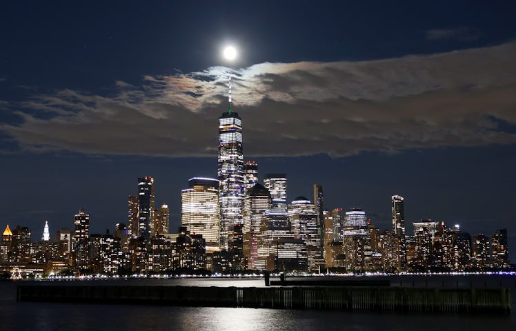 JERSEY CITY, NJ - AUGUST 1: The full Sturgeon Supermoon rises behind the skyline of lower Manhattan ...