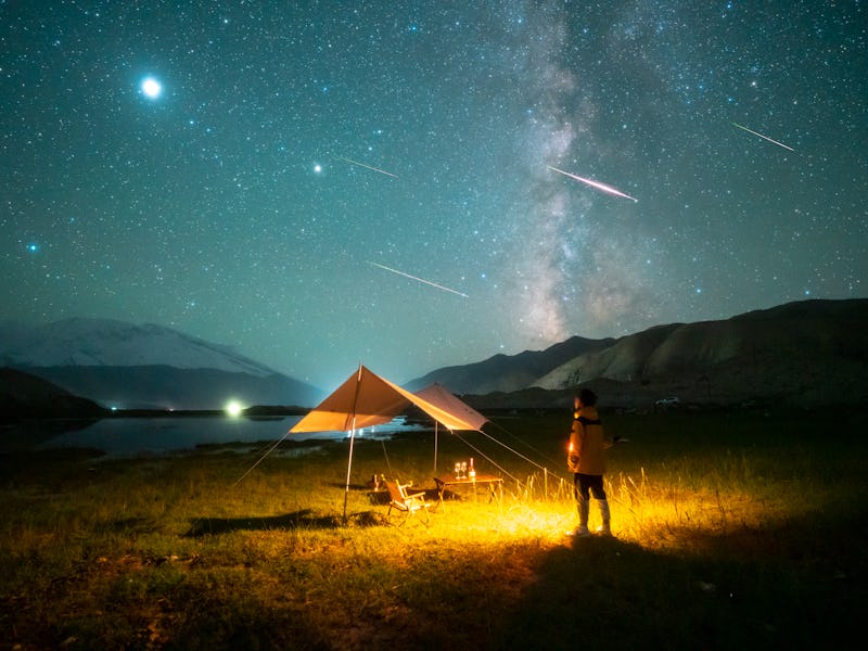 XINJIANG, CHINA - AUGUST 13: A man watches the Perseid meteor shower on the Pamir Plateau on August ...