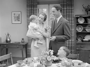 UNITED STATES - CIRCA 1930s: Family at breakfast in dining room.