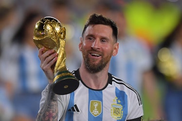 BUENOS AIRES, ARGENTINA - MARCH 23:  Lionel Messi of Argentina celebrates with the FIFA World Cup tr...