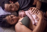 A mother holds her just born baby on her chest at home, in a list of home birth videos that are real...