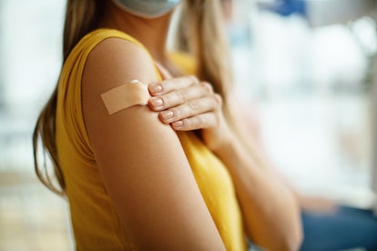 A pregnant woman shows her RSV vaccine band aid. 