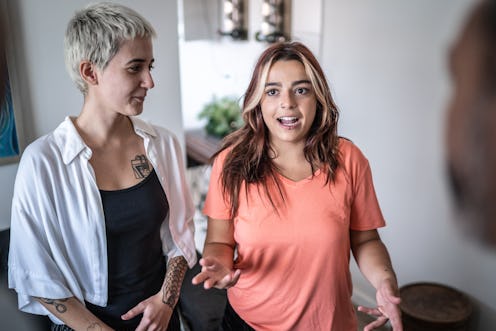 Lesbian couple talking with his friends in living room