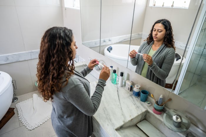 Young woman looking a pregnancy test on bathroom at home