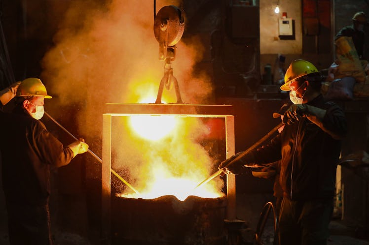 HANGZHOU, CHINA - JANUARY 11: Workers check molten steel from the furnace at a foundry plant on Janu...