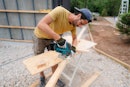 Photo of a carpenter cutting a wooden plank with a power tool