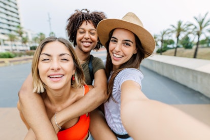 three young women pose for a selfie as they consider how mercury retrograde summer 2023 will affect ...