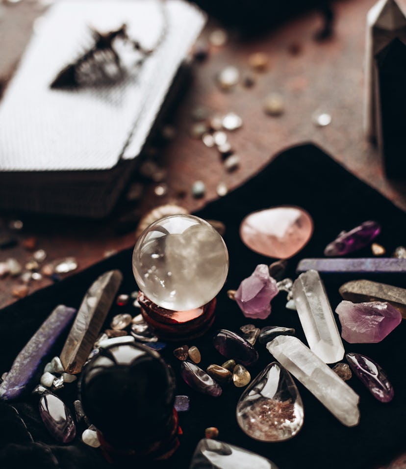 Many various gems and balls on a black bag against the background of tarot cards