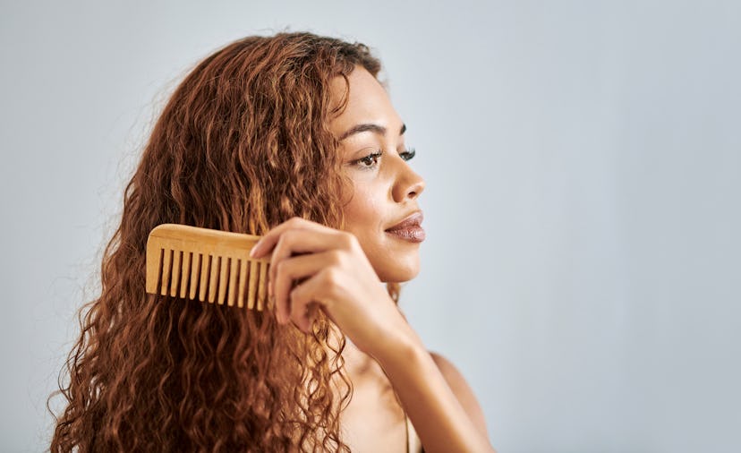 Black woman, beauty and hair comb on a studio gray background mockup. Natural, curly and fashion sty...