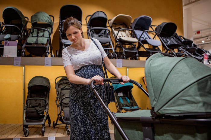 Beautiful pregnant woman stroller shopping, considering how many strollers do I really need