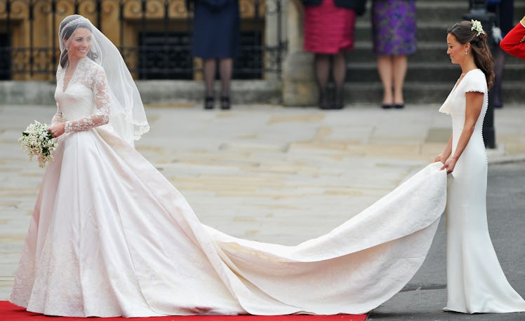 Catherine Middleton waves to the crowds as her sister and Maid of Honour Pippa Middleton 