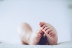 Baby feet up in the air lying down in article about angel baby meaning