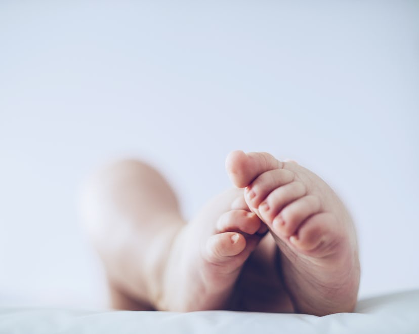 Baby feet up in the air lying down in article about angel baby meaning