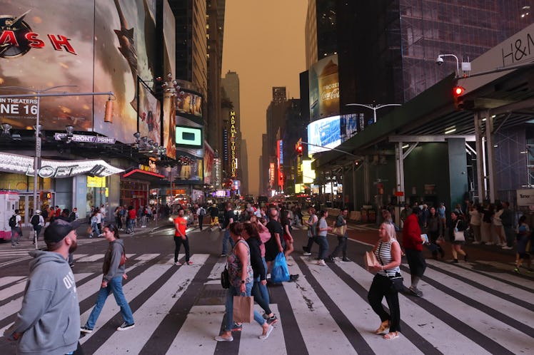 NEW YORK, NY - JUNE 6:  Heavy smoke turns the sky yellow as people walk across 42nd Street in Times ...