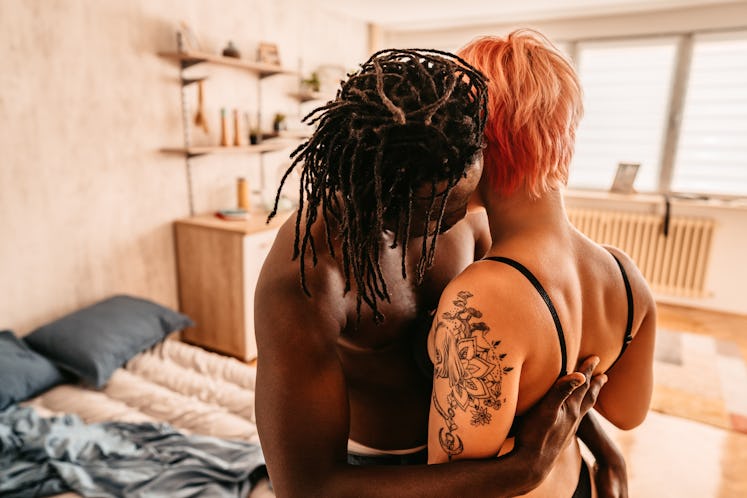 young couple embraces as they consider the kink they should try, based on their zodiac sign