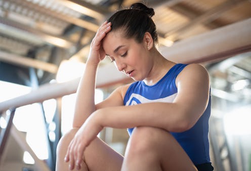 Desperate, frustrated and tired gymnast after a long and tiring training session. Sport and enduranc...