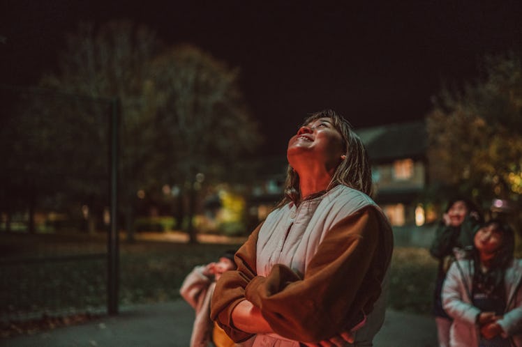 Young Asian woman admiring firework with her family in public park.