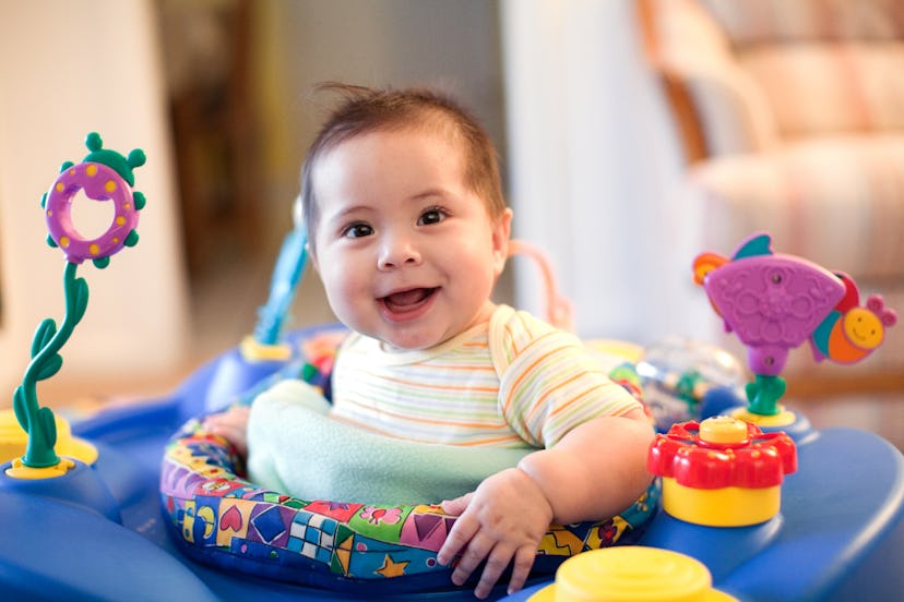 Toddler sits happily in her exersaucer in her living room. Are exersaucers safe?