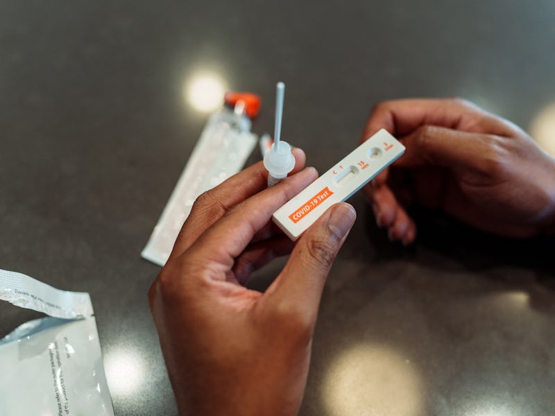 High angle view looking down at the hands of an unrecognizable black man holding the test strip of a...